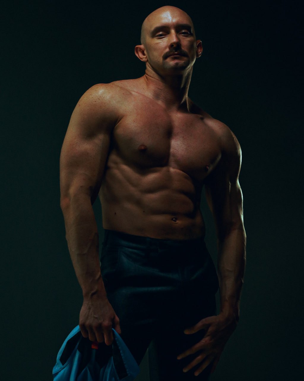 muscular-man-black-pants-shirt-in-hand